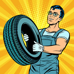 Image showing Male car mechanic with wheel