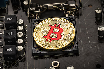 Image showing Gold Bit Coin BTC coins on the motherboard. Bitcoin is a worldwi