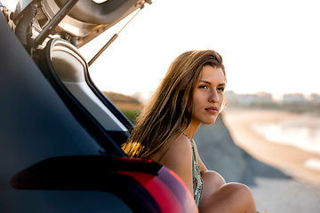 Image showing Girl near the beach sitting on the car