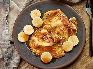 Image showing Crepes with banana and caramel sauce on wooden desk