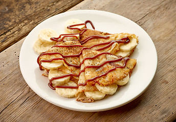 Image showing freshly baked crepes with babana and chocolate sauce