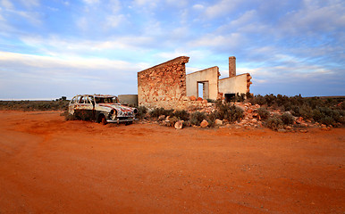 Image showing Crumbling stone home and rusty car