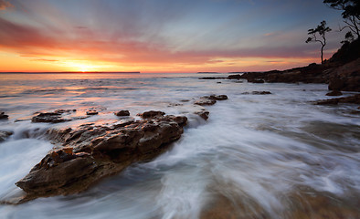 Image showing Sunrise over the Bay with ocean over rocks