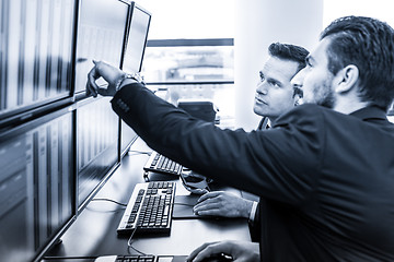 Image showing Stock traders looking at market data on computer screens.