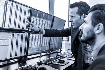 Image showing Stock traders looking at market data on computer screens.