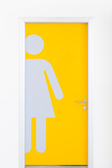 Image showing Women symbols on yellow public toilet entrance door.