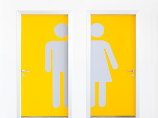 Image showing Men and women symbols on yellow public toilet entrance doors.