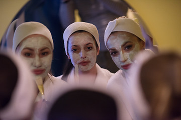 Image showing women putting face masks in the bathroom