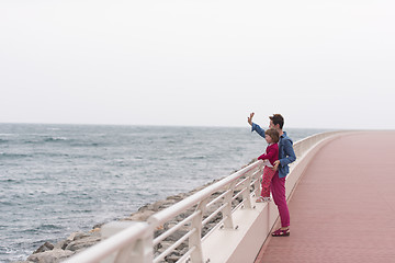 Image showing mother and cute little girl on the promenade by the sea