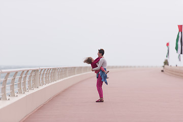 Image showing mother and cute little girl on the promenade by the sea