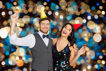 Image showing happy couple with party blowers having fun