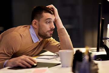 Image showing tired man on table at night office