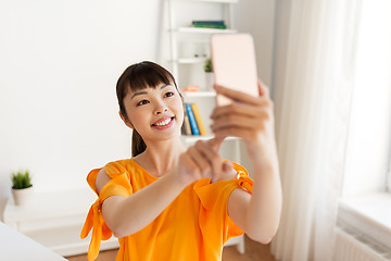 Image showing happy asian woman taking selfie by smartphone