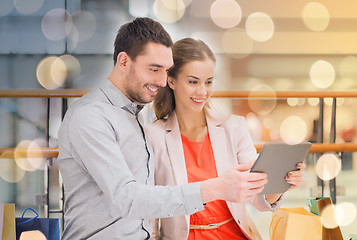 Image showing couple with tablet pc and shopping bags in mall