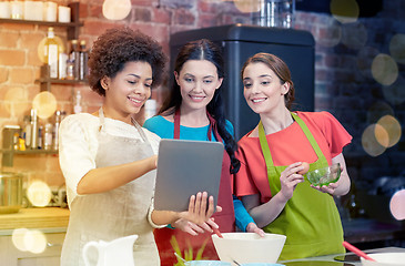 Image showing happy women with tablet pc cooking in kitchen