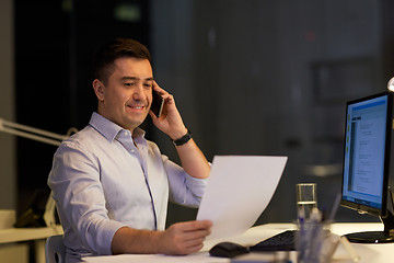 Image showing businessman calling on sartphone at night office