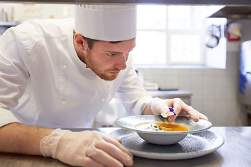 Image showing happy male chef cooking food at restaurant kitchen