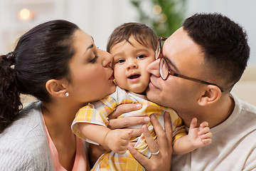 Image showing happy mother and father kissing baby daughter