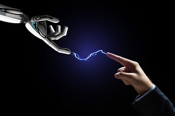 Image showing robot and human hand connected by lightning