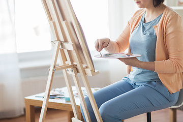 Image showing artist with palette knife painting at art studio