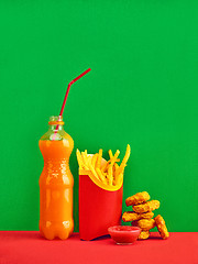 Image showing chicken nuggets and french fries on red background