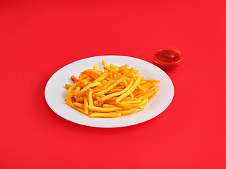 Image showing French fries on a plate, isolated on red background