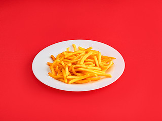 Image showing French fries on a plate, isolated on red background