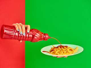 Image showing Young woman with plate of french fries potato with ketchup