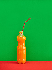 Image showing Glass of fresh orange juice on red background