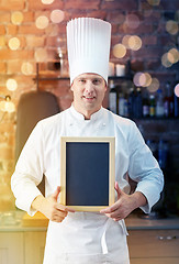 Image showing happy male chef with blank menu board in kitchen