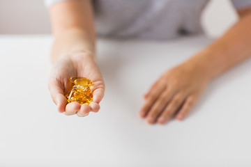 Image showing hand holding cod liver oil capsules