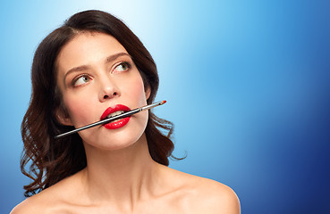 Image showing beautiful woman holding make up brush for lipstick