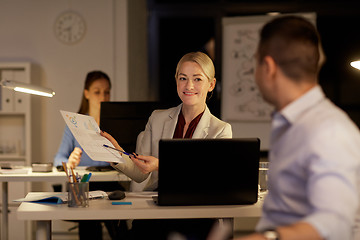 Image showing coworkers with papers working late at night office