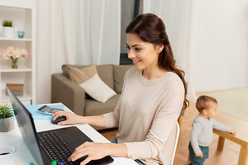 Image showing happy mother with baby and laptop working at home