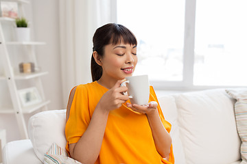 Image showing happy asian woman drinking tea or coffee at home