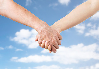 Image showing close up of senior and young woman holding hands