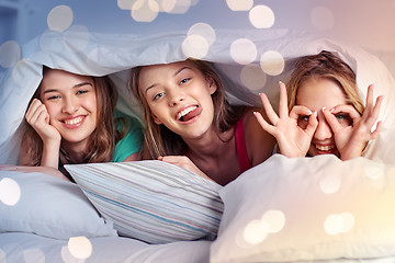 Image showing happy young women in bed at home pajama party