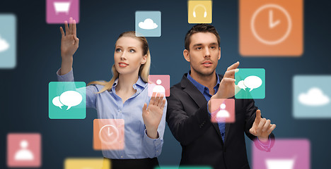 Image showing businessman and businesswoman using virtual icons