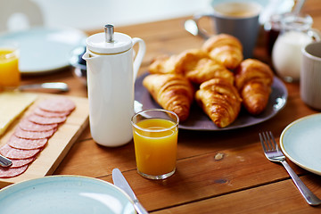 Image showing coffeepot and glass of juice on table at breakfast