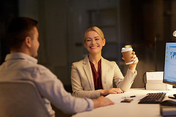 Image showing business people drinking coffee at night office