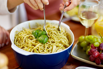 Image showing pasta with basil in bowl and other food on table