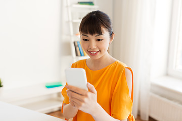 Image showing happy asian woman with smartphone at home