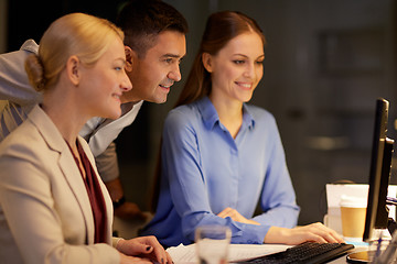 Image showing business team with computer working late at office