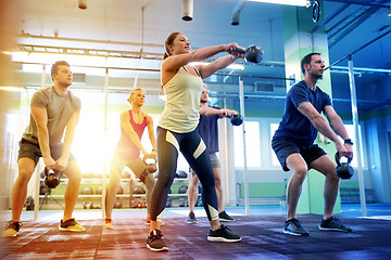 Image showing group of people with kettlebells exercising in gym