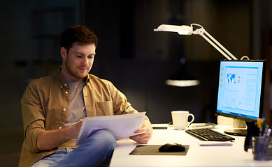 Image showing businessman with papers working at night office