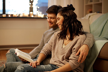 Image showing happy couple reading book at home