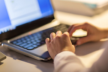 Image showing businesswoman with laptop working at night office