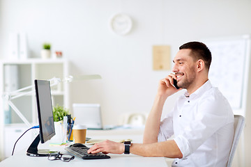 Image showing happy businessman calling on smartphone at office