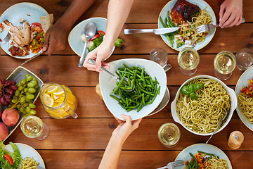 Image showing people at table with food eating green beans