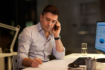 Image showing businessman calling on sartphone at night office